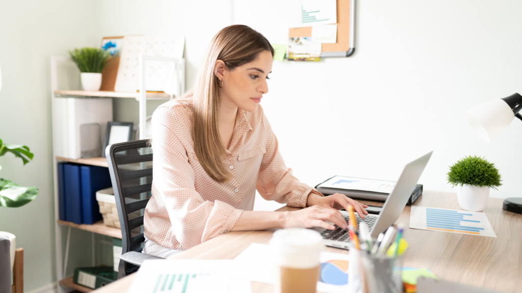 Woman sitting at her desk working on her laptop