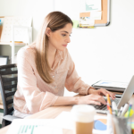 Woman sitting at her desk working on her laptop